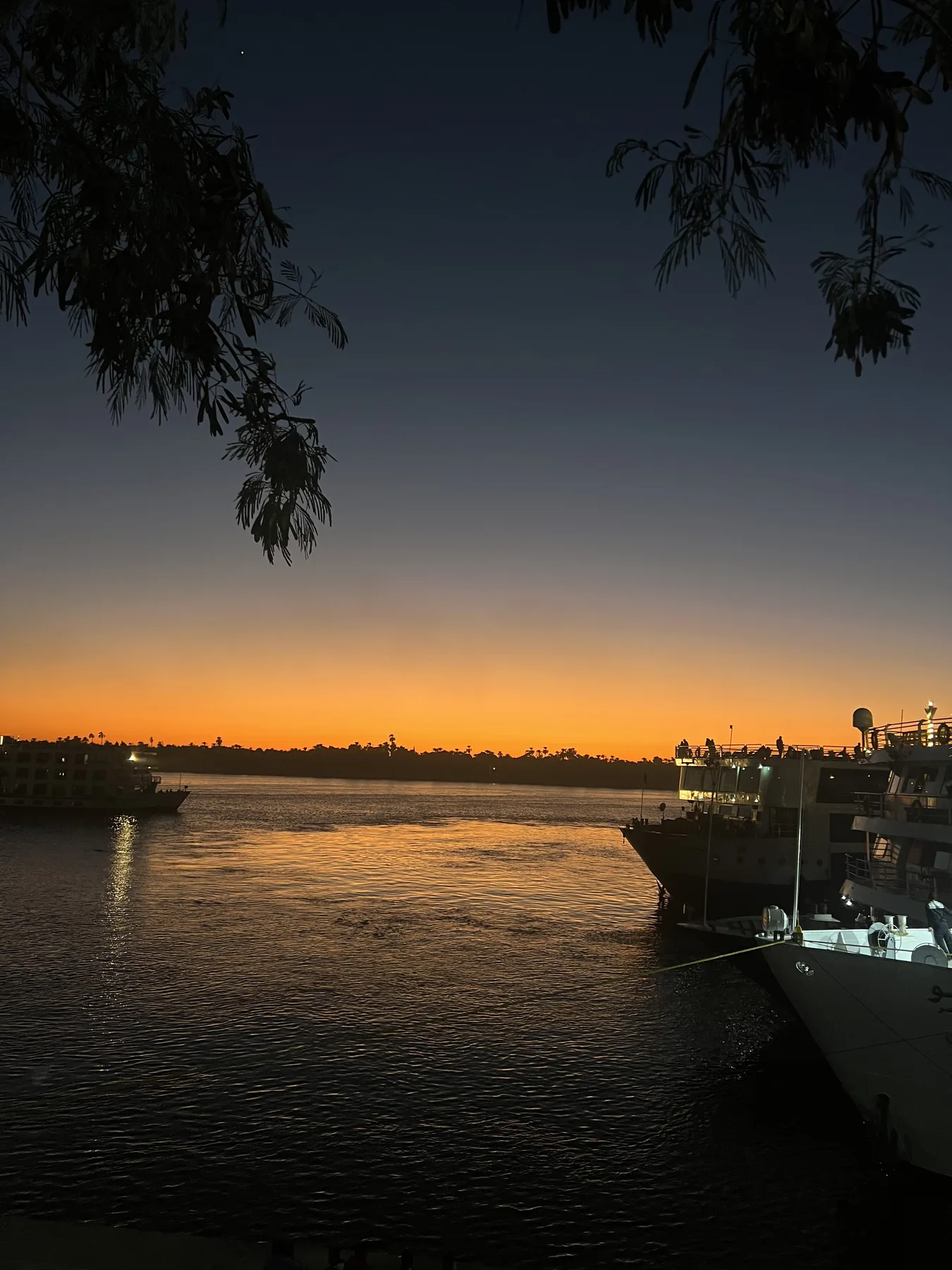 Sunset over the Nile and moored boats in Aswan